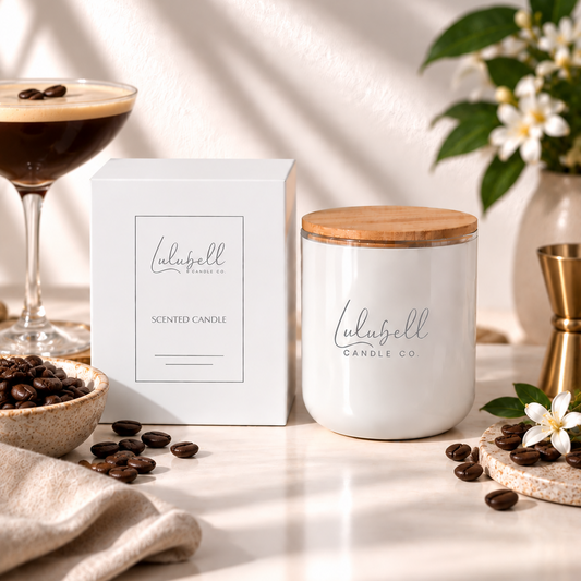 A white scented candle jar with a bamboo lid sits beside its white box on a marble surface. The candle and box are branded 'Lulubell Candle Co.
