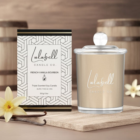 Lulubell Candle Co. candle and packaging on a wooden surface with flowers and vanilla beans.